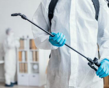 persondisinfectingdangerousareawhilewearingprotectivesuit_1670409647_1670837733